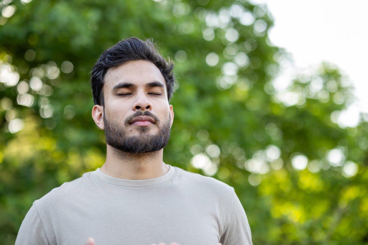 Une personne calme pratiquant la respiration profonde pour apaiser une crise d’angoisse en pleine nature.